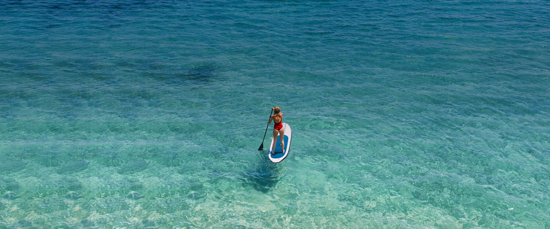 Paddle surfistas explorando aguas turquesas tranquilas en un tour por Ibiza.
