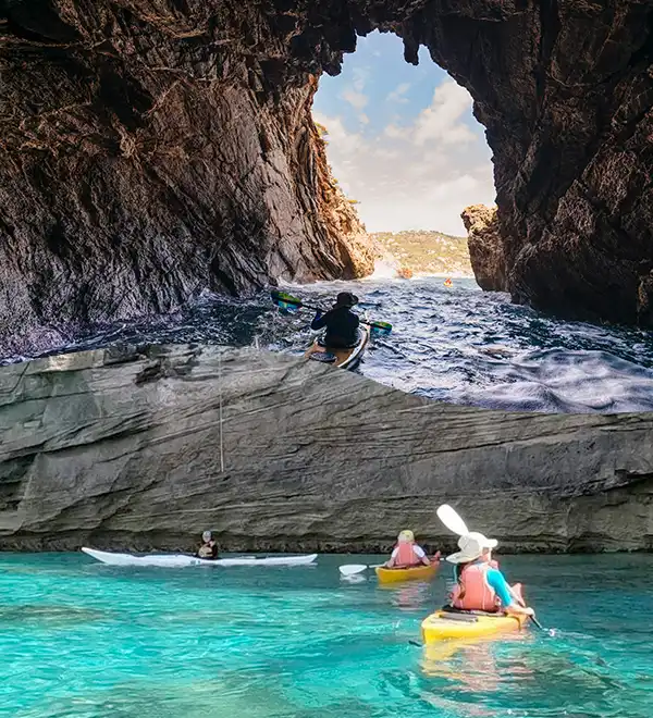 Kayakers exploring dramatic sea caves and turquoise waters on Ibiza coast
